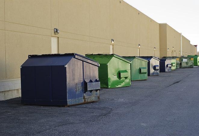 a row of large construction dumpsters on-site in Ballico